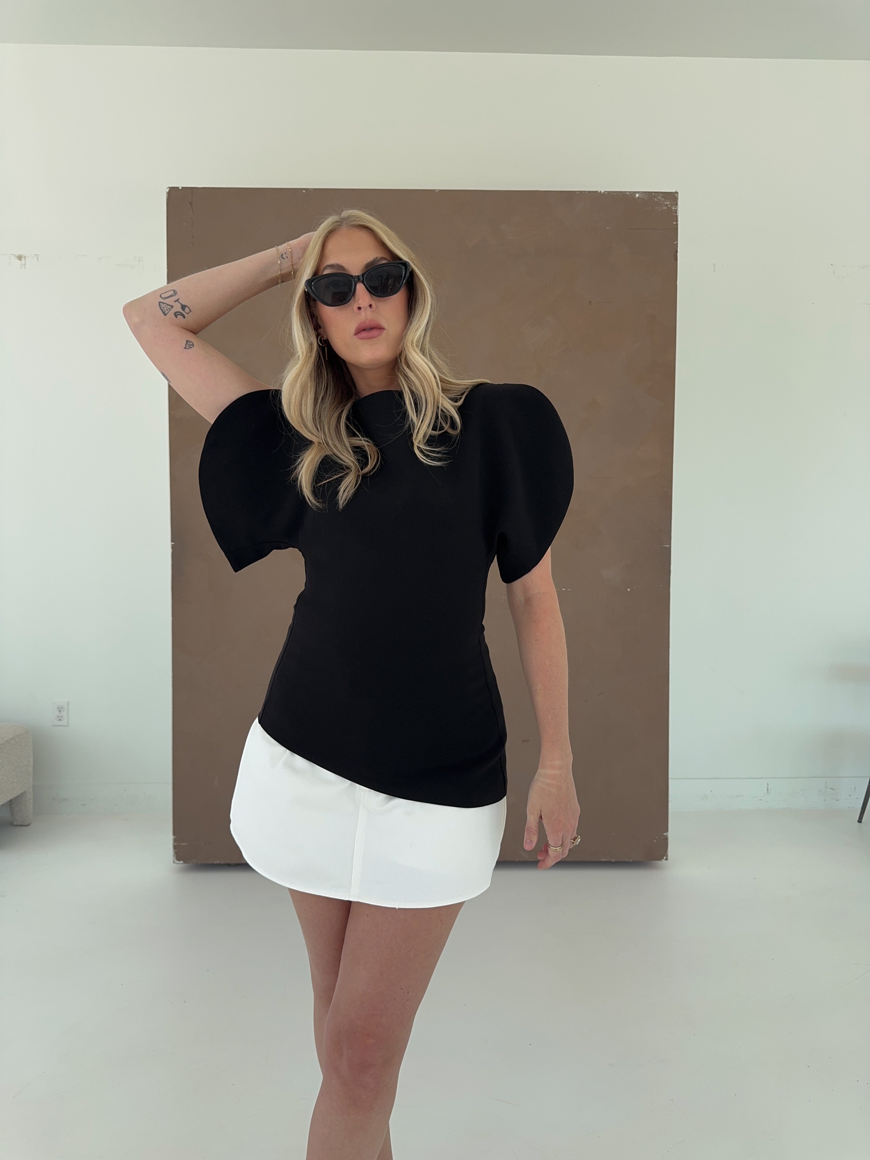 black asymmetrical top with a white denim skort