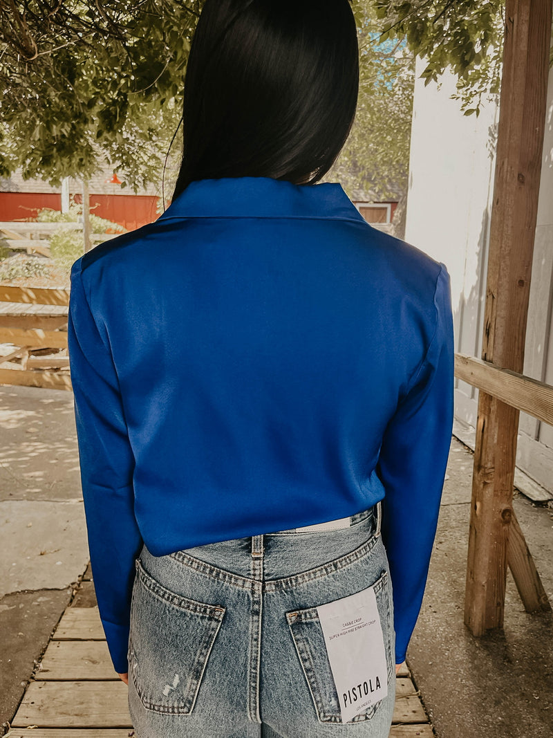 Model wearing royal blue silk crop top, showing off the back.